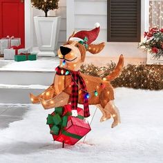 an outdoor christmas decoration with a dog on it's head and presents in its mouth