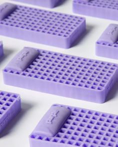 purple legos are arranged in rows on a white surface