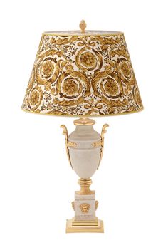 a lamp that is sitting on top of a white base with gold trimmings