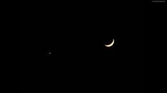 the moon is seen in the dark sky with two smaller crescents visible behind it