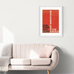 a living room with a white couch and a red poster on the wall above it