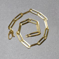 This simple yet dramatic bracelet combines the timeless shine of 14K yellow gold and the modern geometry of paperclip chain links. Bracelet is 7 1/2 inches long, 4.2mm wide, and closes with a lobster clasp.Product Details: Bracelet Information : Metal : 14K Yellow Gold Chain Type : Link Clasp : Lobster Clasp Width : 0.17 in Approximate Weight: Size Weight 7.5'' 2.5 grams Modern Paperclip Link Bracelet For Gift, Modern Link Paperclip Bracelet As Gift, Modern Gold Bracelet With Box Chain, Formal Link Paperclip Bracelet With Lobster Clasp, Modern Gold Chain Bracelet With Paperclip Chain, Gold-tone Link Paperclip Bracelet With Lobster Clasp, Modern Gold Chain Bracelet With Hook And Links, Modern Chain Link Bracelet With Hooks And Links, Gold Chain Bracelet With Hook And Links For Everyday