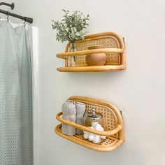 two bamboo shelfs holding towels and other items in a bathroom with a shower curtain