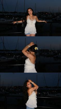 a woman in white shirt standing next to water at night