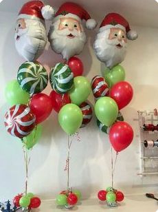 christmas balloons and santa clause heads hanging on the wall