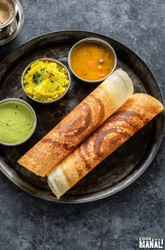 a plate with some food on it and two dipping sauces next to each other