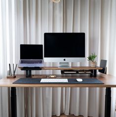 two computer monitors sitting on top of a wooden desk