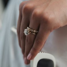 a close up of a person's hand holding a ring