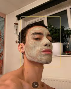 a man with facial mask on looking at his reflection in the mirror to see what he is doing