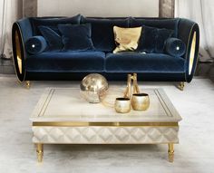 a living room with blue velvet couches and gold accented coffee table in the middle