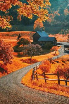 a rural country road with a barn in the background and autumn foliage on the other side