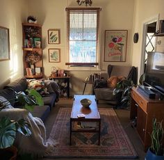 a living room filled with furniture and a flat screen tv sitting on top of a wooden table