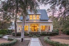 a white house surrounded by trees and bushes