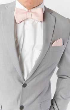 a man in a gray suit with a pink bow tie