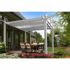 an outdoor dining table and chairs under a pergolated patio cover with flowers in the foreground