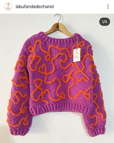 a purple sweater with orange hearts on it