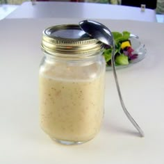 a glass jar filled with food sitting on top of a table next to a plate