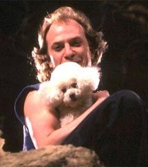 a man holding a white dog in his arms