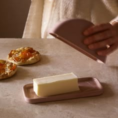 a person is pouring cheese onto small pastries