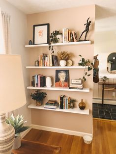 a living room filled with lots of furniture and bookshelves next to a lamp