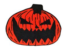 a black and orange pumpkin shaped rug with an evil face on it's side