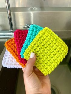 four crocheted dishcloths are sitting on the sink in front of a faucet