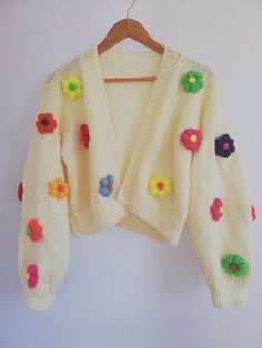 a white sweater with colorful flowers on it