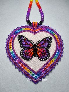 a colorful beaded heart with a butterfly on it