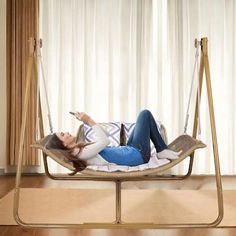 a woman laying in a hammock swing