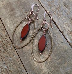 "Burnt orange Czech glass ovals dangle inside a hammered, antiqued copper hoop. The perfect spring and summer earrings! These earrings are a new addition to my original hammered copper hoop collection. This pair features burnt orange Czech glass elongated ovals with a rustic finish, a perfect compliment to the warm antiqued copper. These earrings will add just a bit of color to your look without being flashy. Product overview: - Made with Czech glass and hammered, antiqued copper - Very light-we Brown Small Hoop Earrings With Ear Wire, Unique Rust-colored Earrings With Ear Wire, Unique Rust Earrings With Ear Wire, Brown Hoop Jewelry With Ear Wire, Brown Teardrop Hoop Earrings With Ear Wire, Nickel-free Rust Drop Earrings, Brown Metal Hoop Earrings, Rust Dangle Earrings With Ear Wire, Rust Color Dangle Earrings With Ear Wire