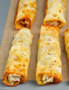 several different types of food sitting on a tray with one rolled up and the other uncooked