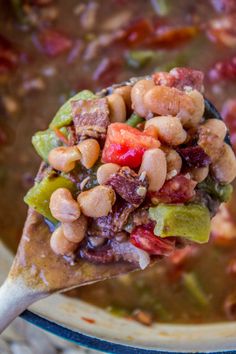 a spoon full of soup with beans and vegetables