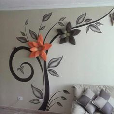 a bed room with a neatly made bed and flowers on the wall