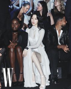 a group of people sitting next to each other at a fashion show