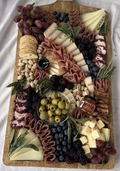 an assortment of cheeses, olives, and meats on a platter