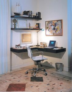 a desk with a laptop on top of it in front of a shelf filled with books