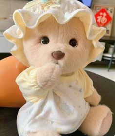 a stuffed teddy bear wearing a white outfit