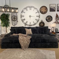 a large black couch sitting in front of a clock on the wall