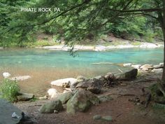 the water is crystal blue and green in this photo, with rocks on the shore