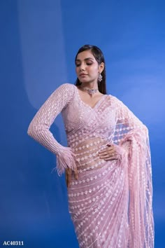 a woman in a pink sari and matching jewelry poses for the camera with her hands on her hips