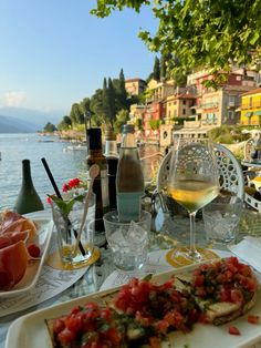 there is a plate of food on the table next to some wine bottles and glasses