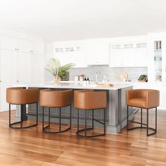 a kitchen island with four stools in front of it