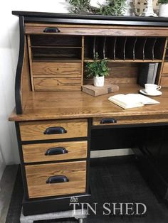 a wooden desk with drawers and a potted plant sitting on it's top