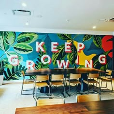 a classroom with desks and chairs in front of a colorful mural on the wall