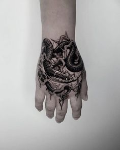 a person's hand with a tattoo on it and a dragon in the middle