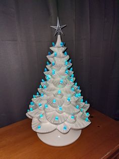 a white ceramic christmas tree with blue lights