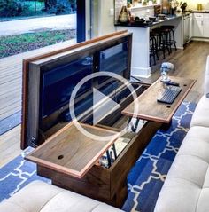 a living room filled with furniture and a flat screen tv sitting on top of a wooden table