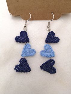 the earrings are made out of blue and white seed beading, with hearts on them