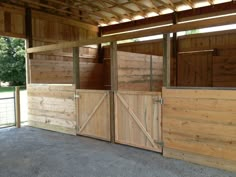 the inside of a horse barn with doors open