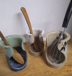 three ceramic utensils are lined up on a table